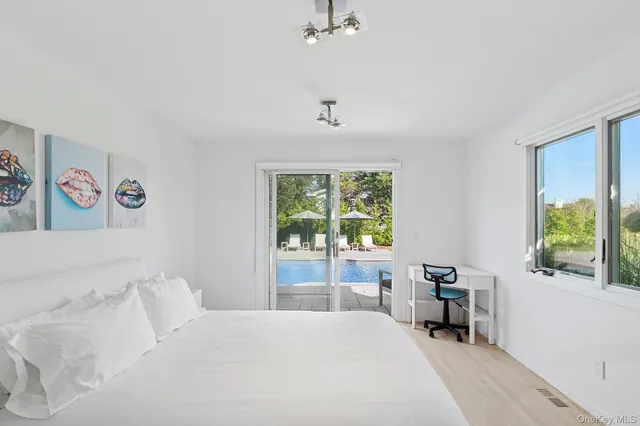 a bedroom with a bed and a table in it with window