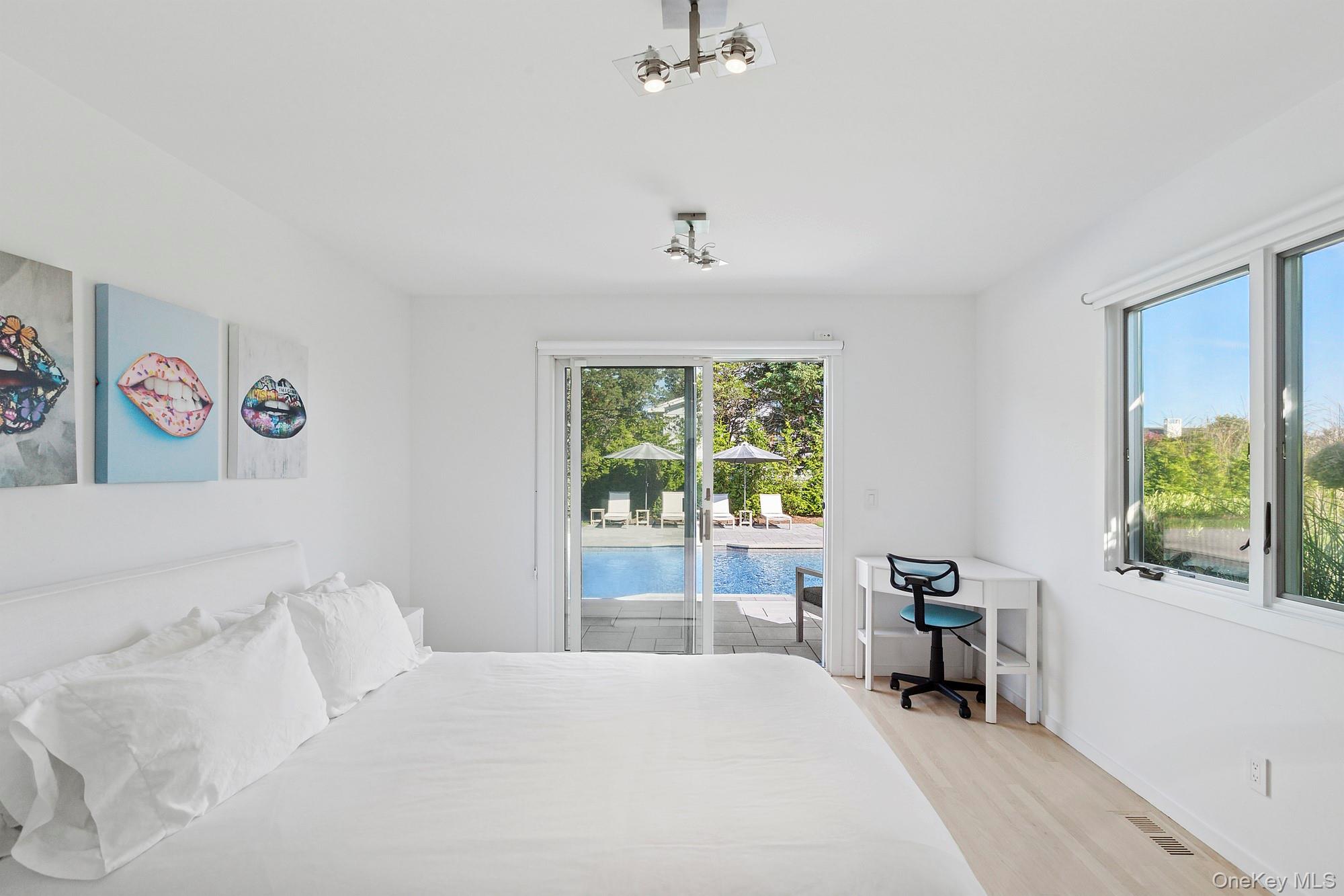 4 Bayberry Lane Remsenburg, NY 11960 - Photo 12 of 27 a bedroom with a bed and a table in it with window