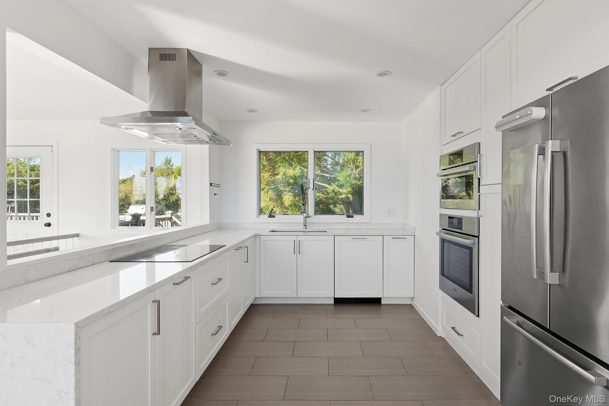 4 Bayberry Lane Remsenburg, NY 11960 - Photo 5 of 27 a large white kitchen with cabinets a window and stainless steel appliances