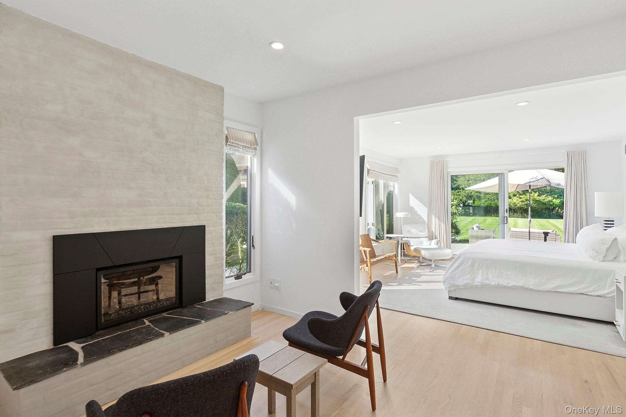 4 Bayberry Lane Remsenburg, NY 11960 - Photo 9 of 27 a living room with furniture a large window and a fireplace