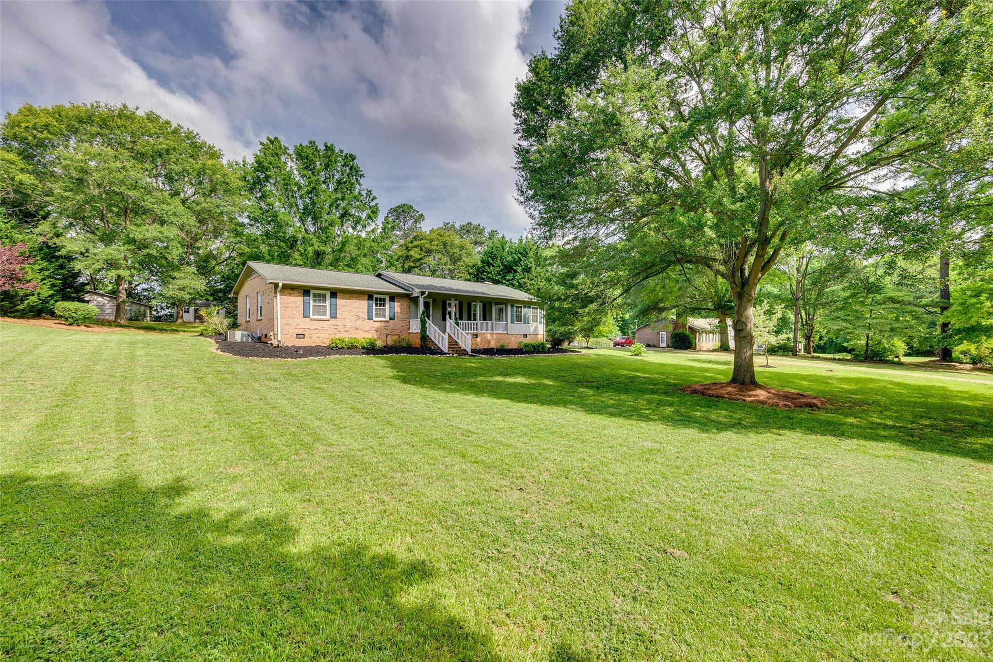 a view of house with yard and trees in the background