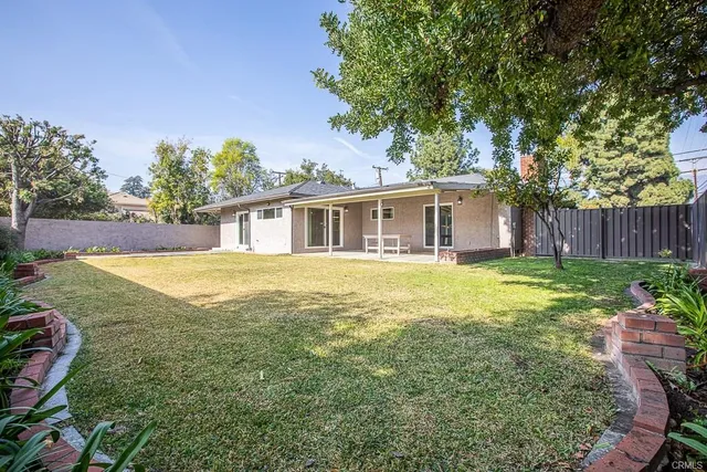 a view of backyard with swimming pool and seating space