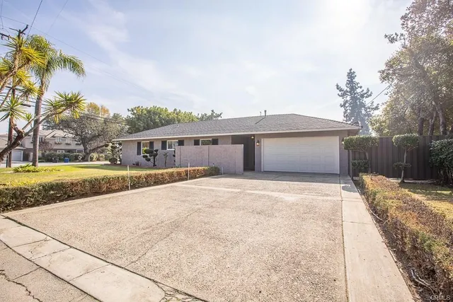a front view of a house with a garden and yard