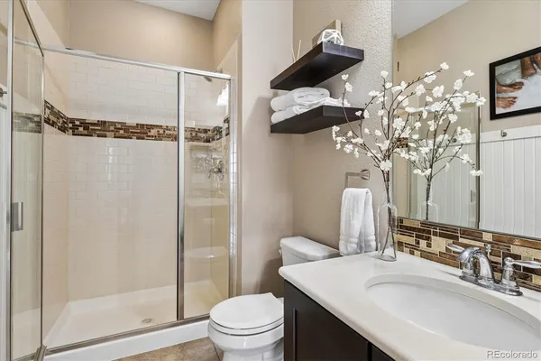 a bathroom with a sink toilet mirror and shower