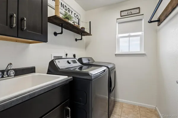 a utility room with sink dryer and washer