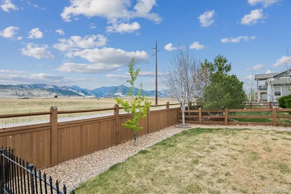 a view of a backyard with wooden fence