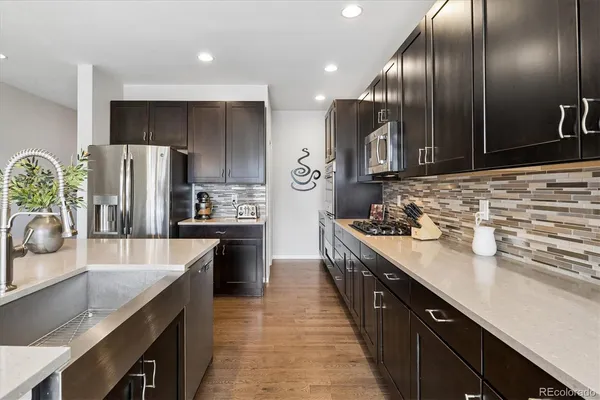 a kitchen with stainless steel appliances granite countertop a sink a stove and refrigerator