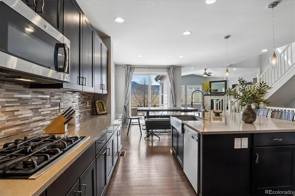 a kitchen with kitchen island granite countertop lots of counter top space a sink and appliances