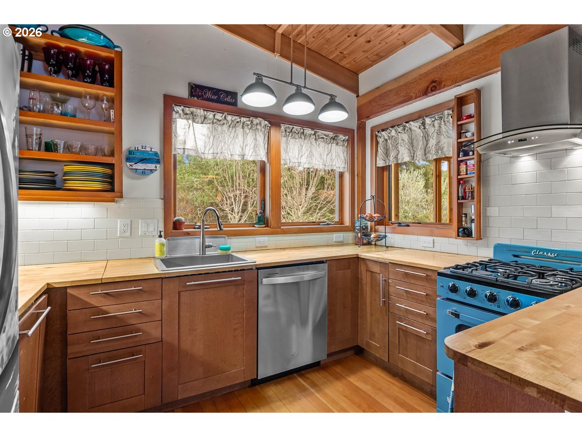 4975 Heceta Beach Road Florence, OR 97439 - Photo 13 of 48 a kitchen with stainless steel appliances kitchen island granite countertop a sink and wooden cabinets