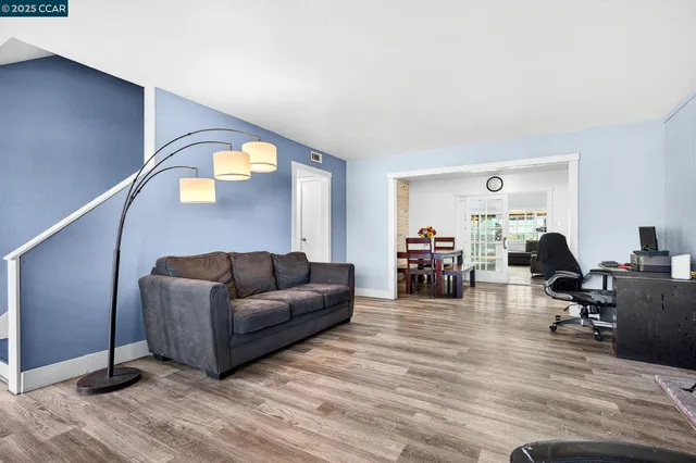 a living room with furniture and a wooden floor