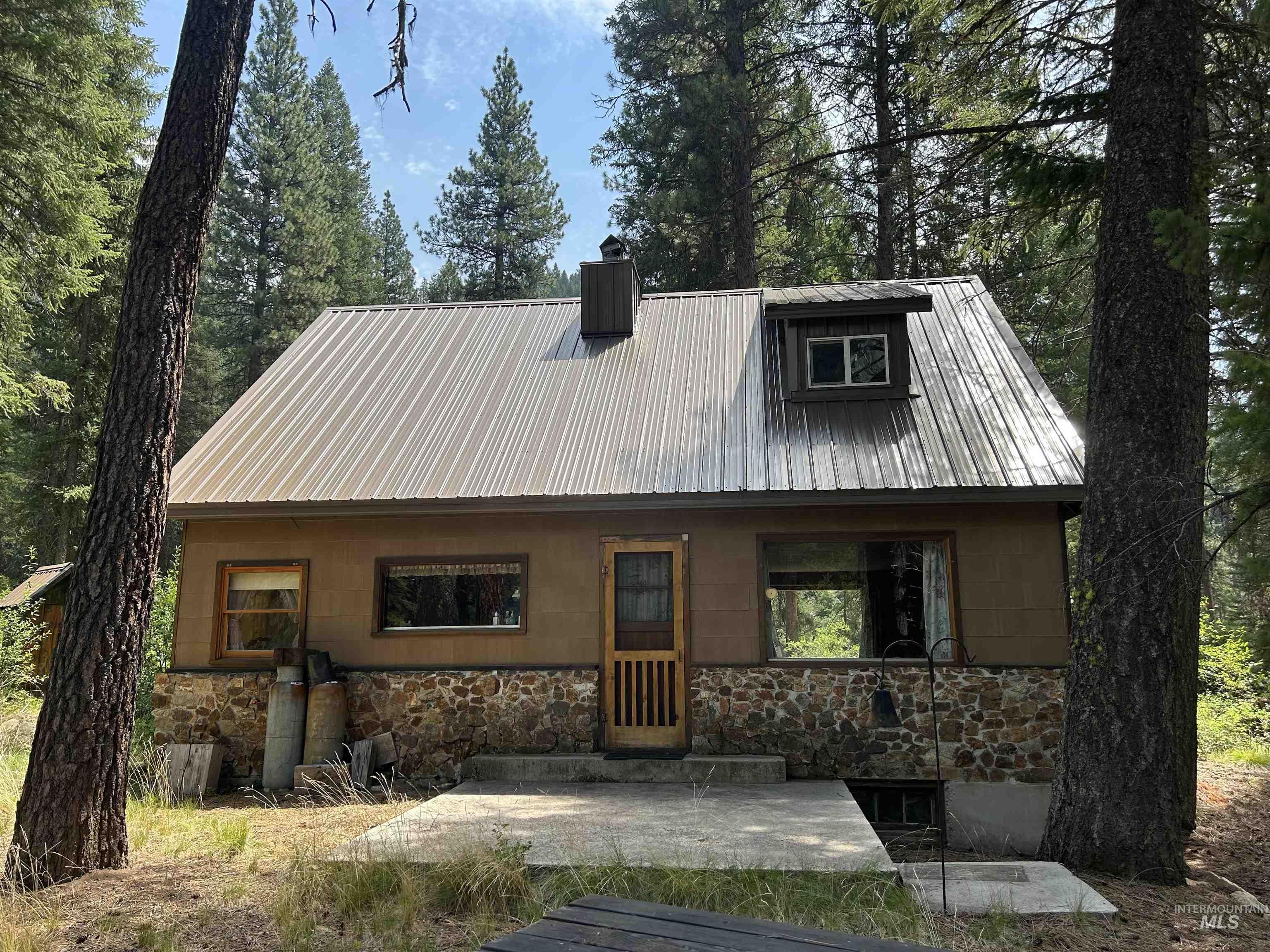 44 Long Creek Road Lowman, ID 83637 - Photo 6 of 42 Stone-clad fireplace featuring a wood-burning stove and a stone hearth