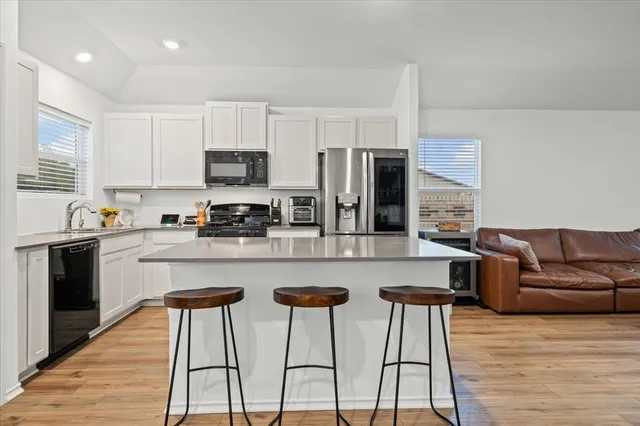 a kitchen with stainless steel appliances granite countertop a refrigerator a stove top oven a sink and dishwasher