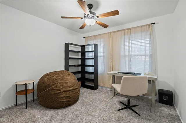 a view of a workspace with furniture and a window