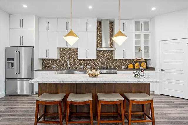 a kitchen with granite countertop a table chairs stove and refrigerator