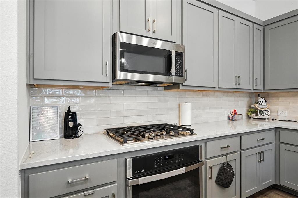 6535 Baritone Court Sachse, TX 75048 - Photo 7 of 24 a kitchen with microwave cabinets and stove top oven