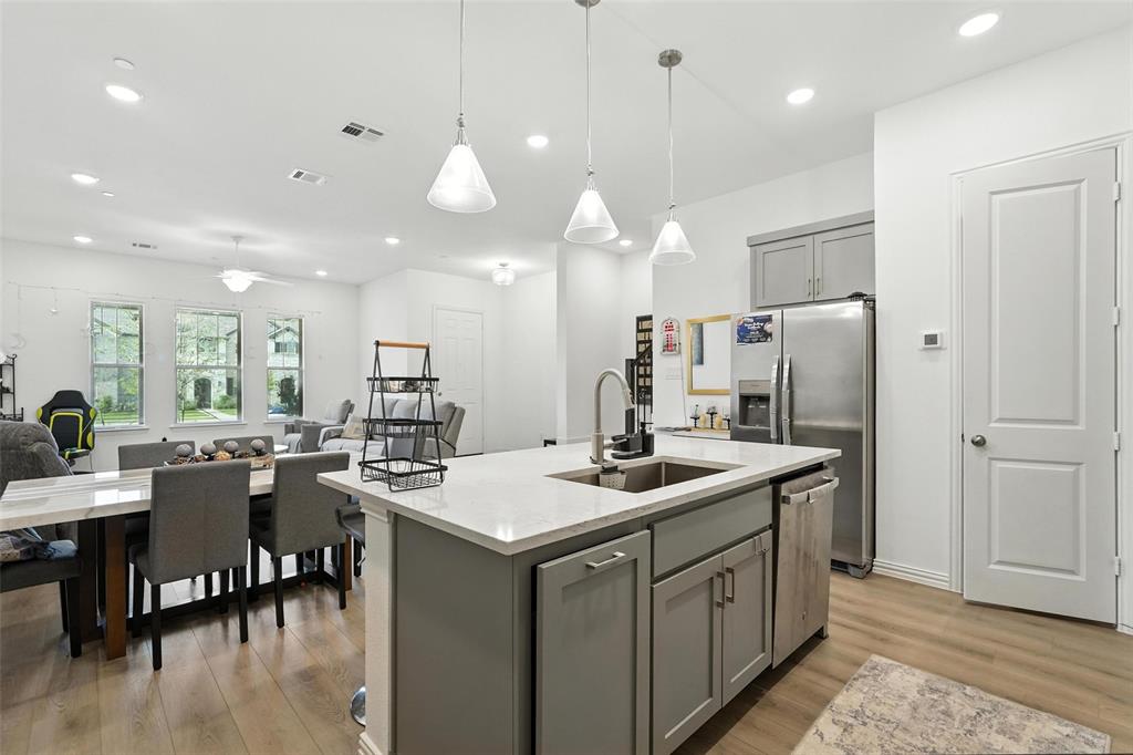 6535 Baritone Court Sachse, TX 75048 - Photo 21 of 24 a kitchen with center island white cabinets and stainless steel appliances