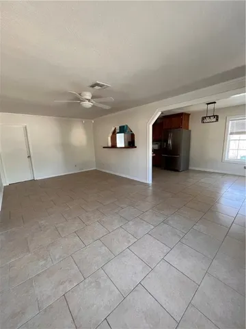 an empty room with windows and ceiling fan