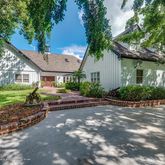 a view of a house with a yard and large tree