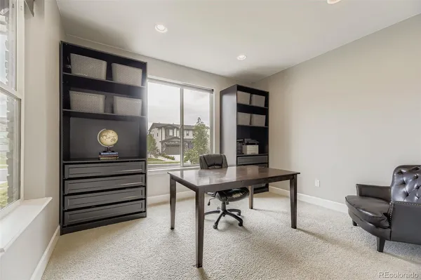 a view of a workspace with furniture and a window