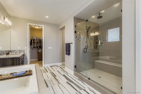 a bathroom with a tub a sink and a shower