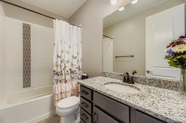 a bathroom with a granite countertop sink a toilet and a bathtub