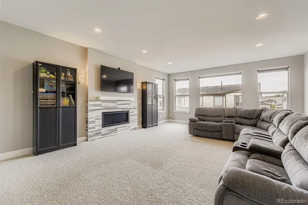 a living room with furniture a flat screen tv and a fireplace