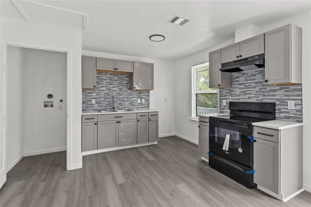 a kitchen with a hard wood floor and a stove