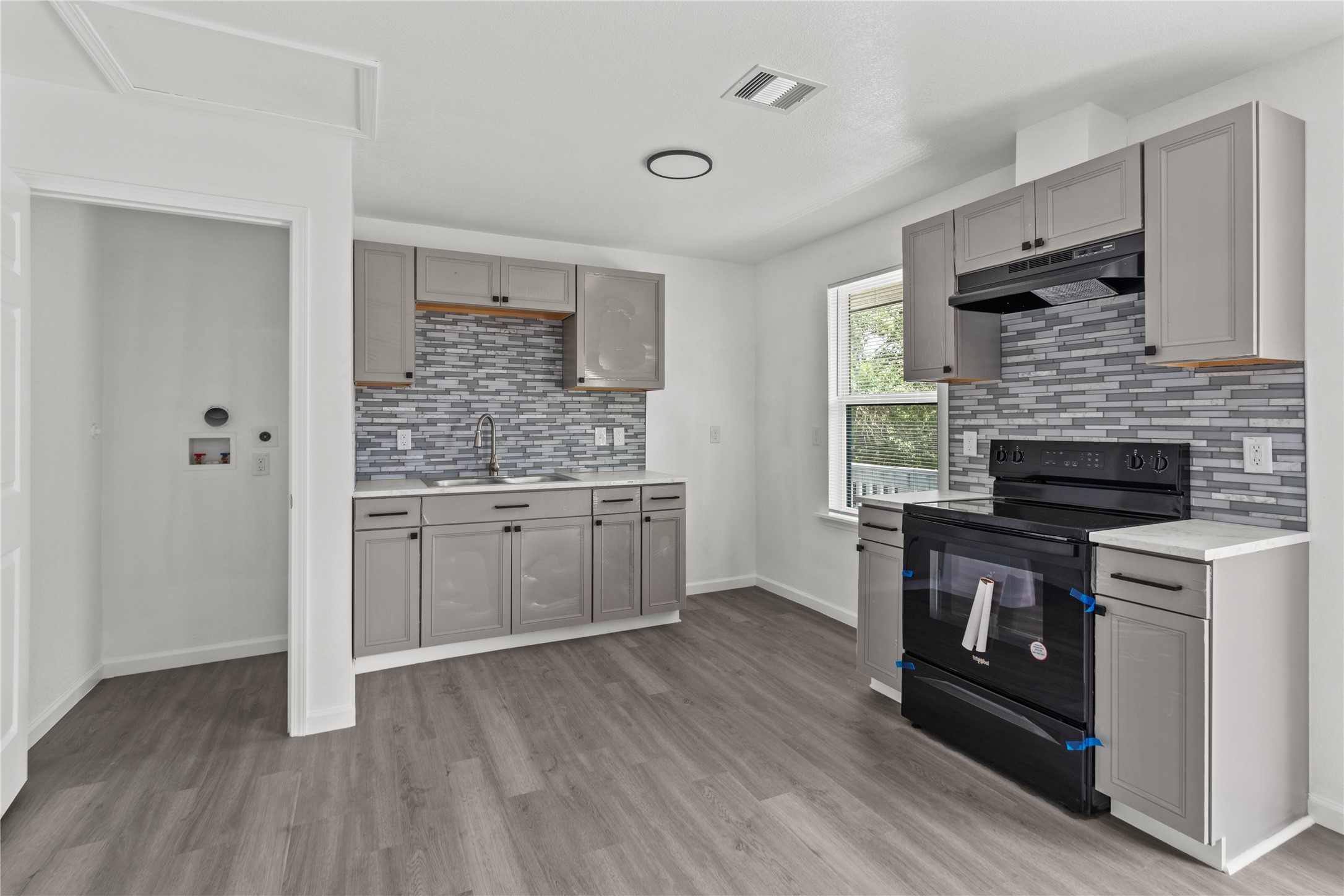 a kitchen with a hard wood floor and a stove