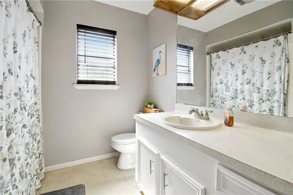 a bathroom with a sink toilet and window