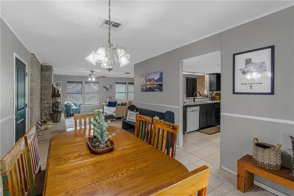 a view of a dining room with furniture a chandelier and wooden floor