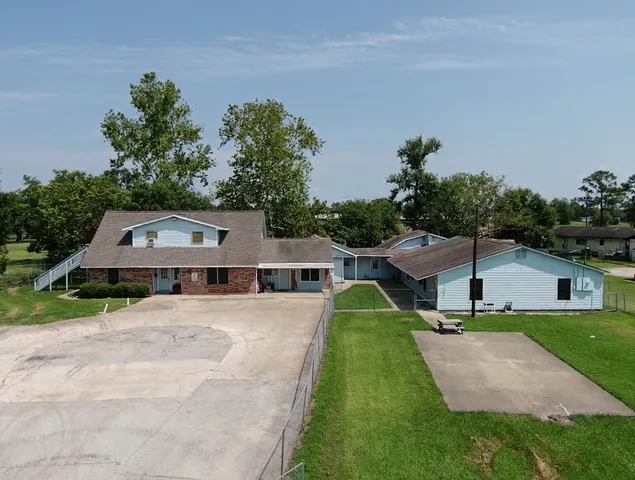 a view of house with garden and tall trees
