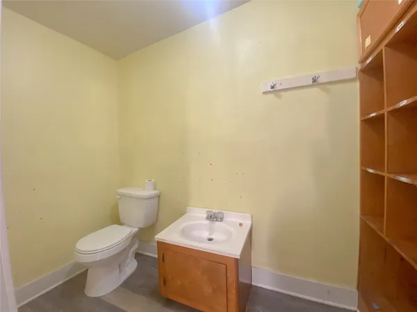 a white toilet sitting next to a white wall