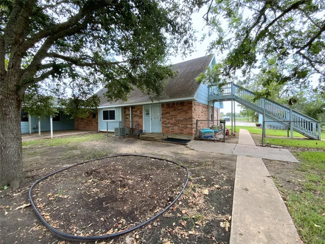a view of a house with a tree next to a yard