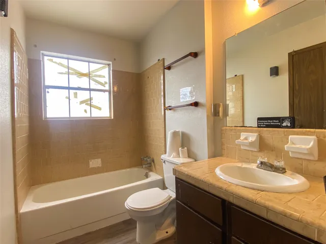 a bathroom with a granite countertop sink mirror toilet and bathtub