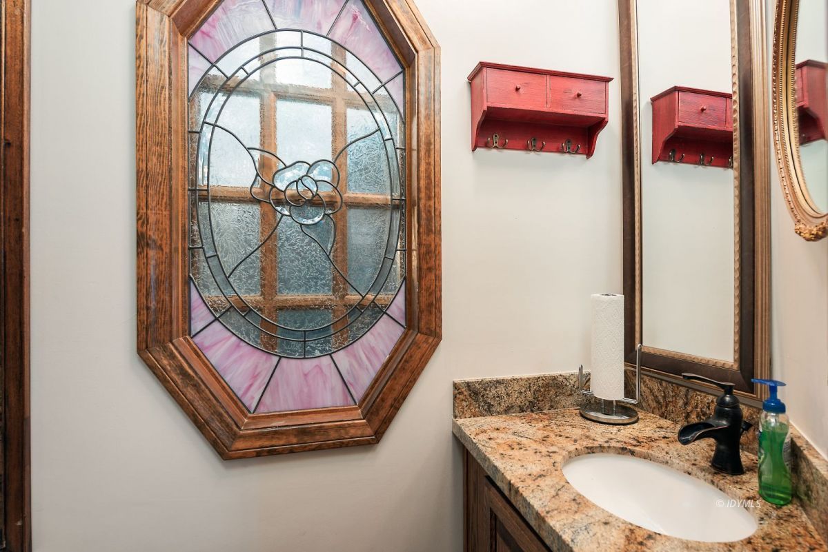 52595 Idyllmont Road Idyllwild, CA 92549 - Photo 22 of 58 a bathroom with a granite countertop sink a mirror and a shower