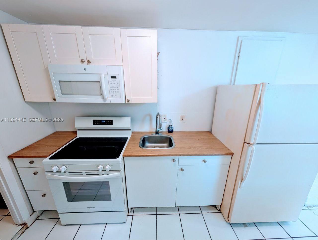 a kitchen with a sink a stove and cabinets