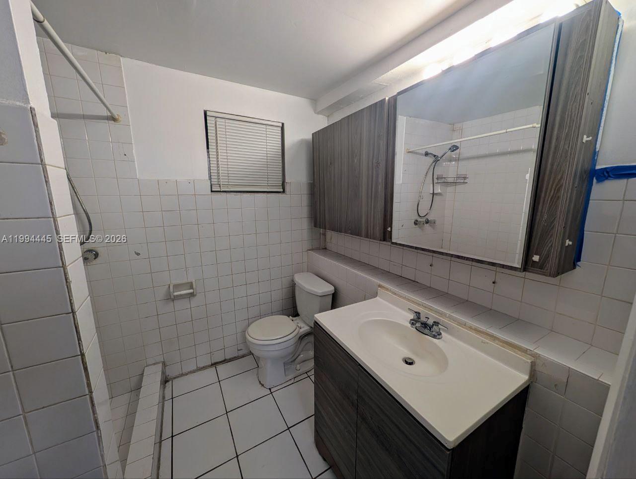 1825 Harding Street, Unit 5 Hollywood, FL 33020 - Photo 6 of 7 a bathroom with a sink mirror and toilet