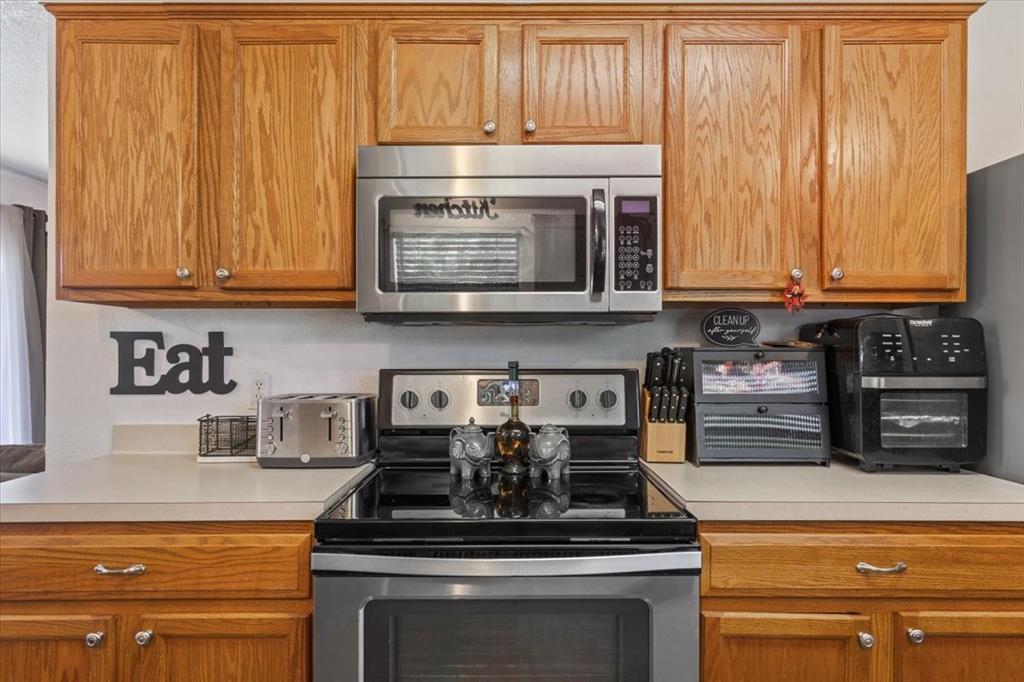 10817 Lilry Road Waco, TX 76708 - Photo 13 of 27 Kitchen featuring stainless steel appliances, light countertops, and wood finish cabinetry