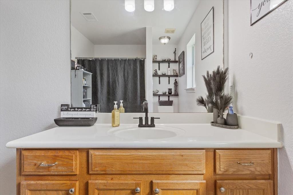 10817 Lilry Road Waco, TX 76708 - Photo 20 of 27 Bathroom with a textured wall, vanity, and a shower with shower curtain
