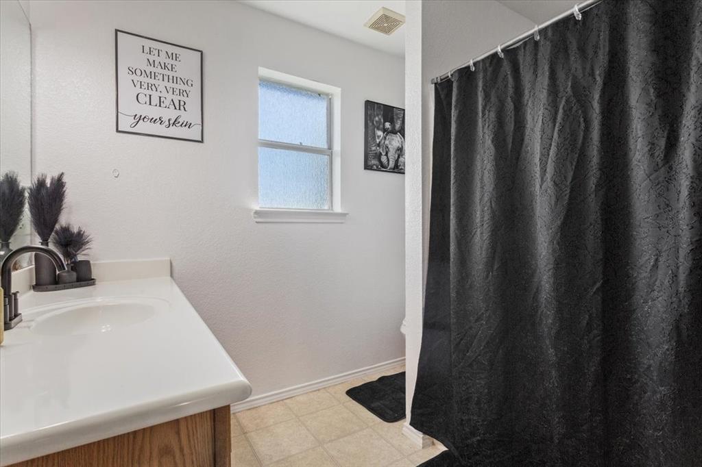 10817 Lilry Road Waco, TX 76708 - Photo 21 of 27 Bathroom featuring vanity, light floors, and curtained shower