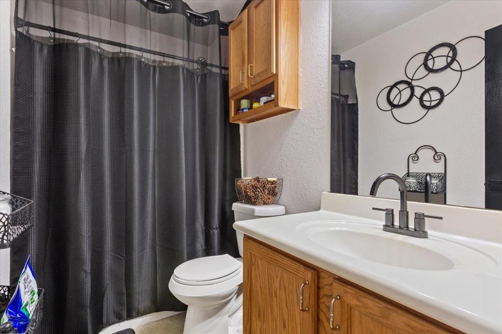 10817 Lilry Road Waco, TX 76708 - Photo 22 of 27 Full bath with a textured wall, vanity, and a shower with shower curtain
