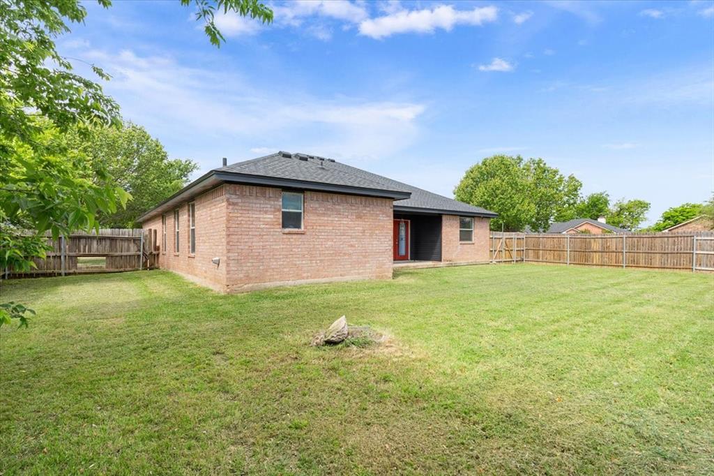10817 Lilry Road Waco, TX 76708 - Photo 25 of 27 Rear view of house with a patio, a fenced backyard, brick siding, and roof with shingles