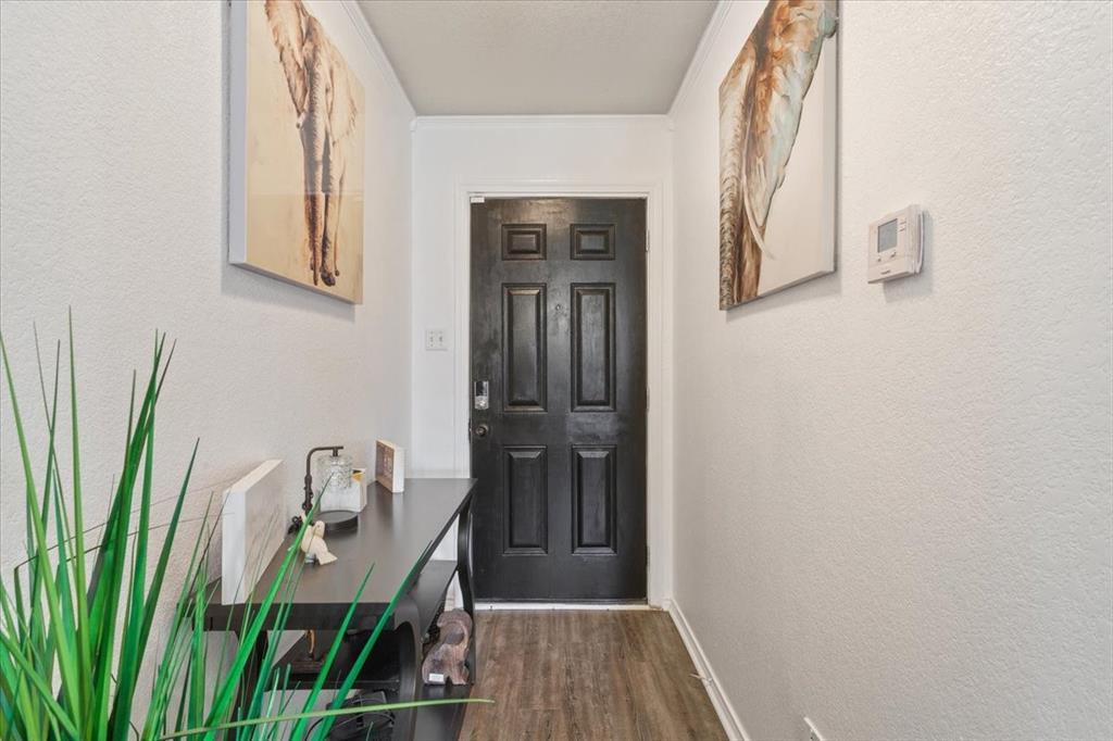 10817 Lilry Road Waco, TX 76708 - Photo 5 of 27 Doorway to outside featuring a textured wall, wood finished floors, and ornamental molding