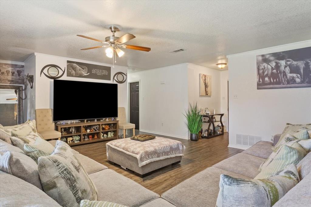10817 Lilry Road Waco, TX 76708 - Photo 7 of 27 Living room with a textured ceiling, a ceiling fan, and wood finished floors