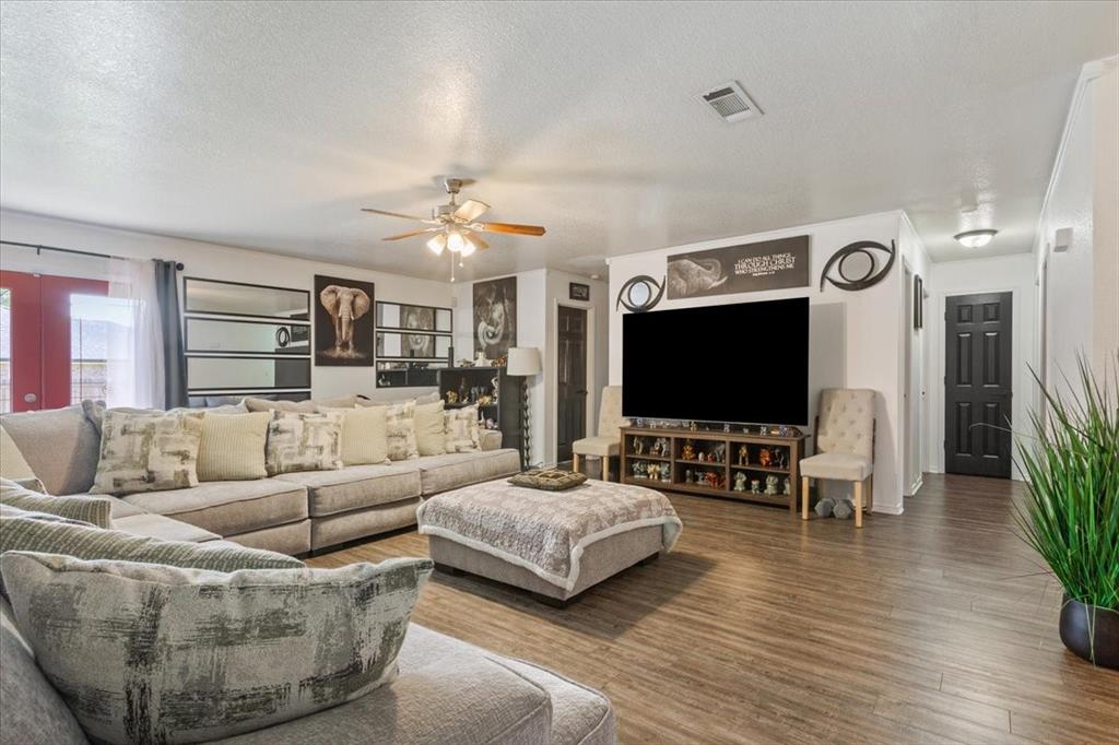 10817 Lilry Road Waco, TX 76708 - Photo 8 of 27 Living area with a textured ceiling, wood finished floors, and ceiling fan
