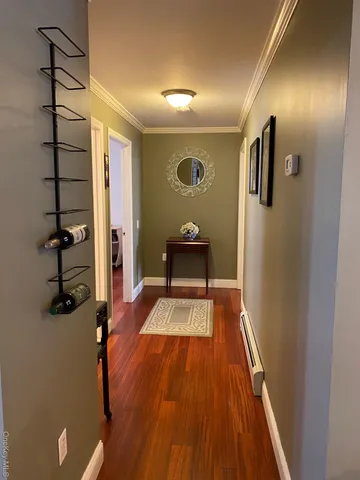 a view of a hallway with wooden floor and workspace