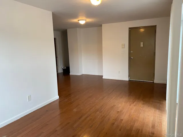 an empty room with wooden floor and closet