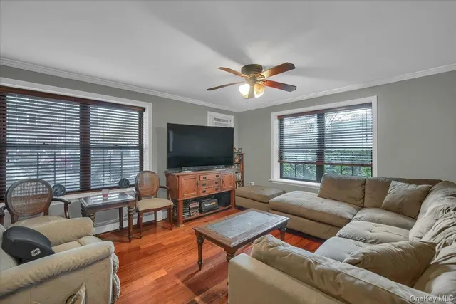 a living room with furniture flat screen tv and a large window