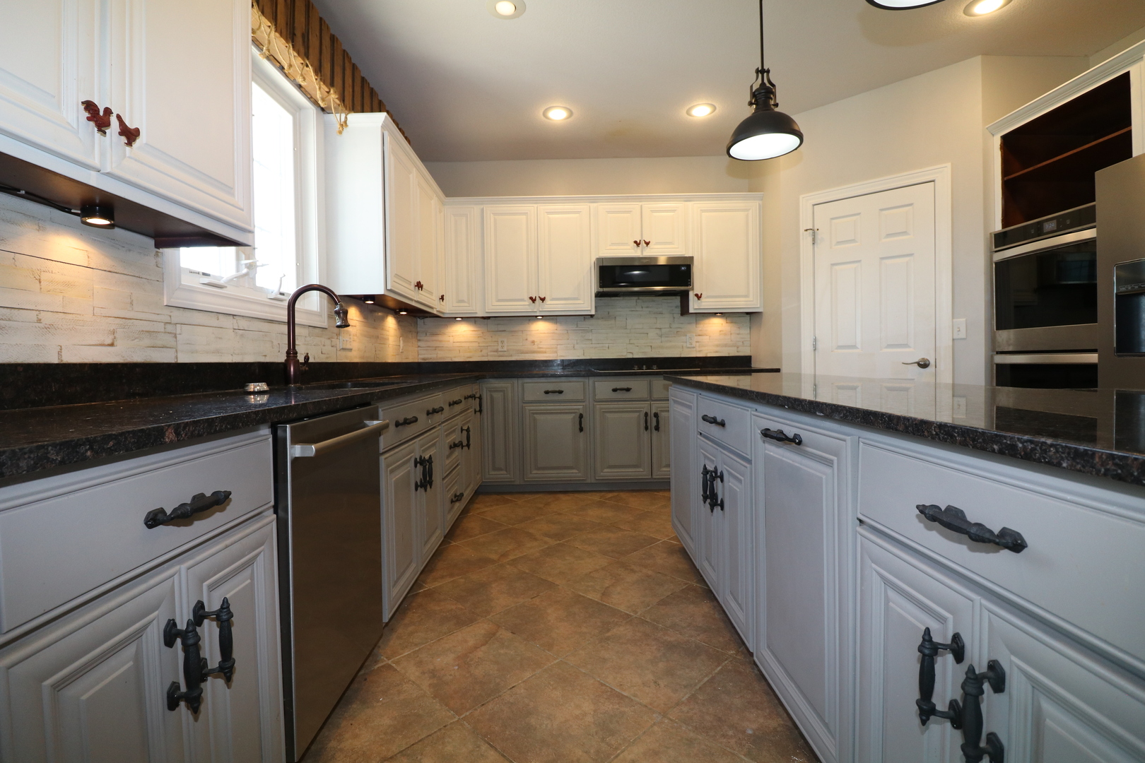 9358 Little Galilee Road Clinton, IL 61727 - Photo 20 of 40 a large kitchen with stainless steel appliances kitchen island granite countertop a stove a sink and a microwave