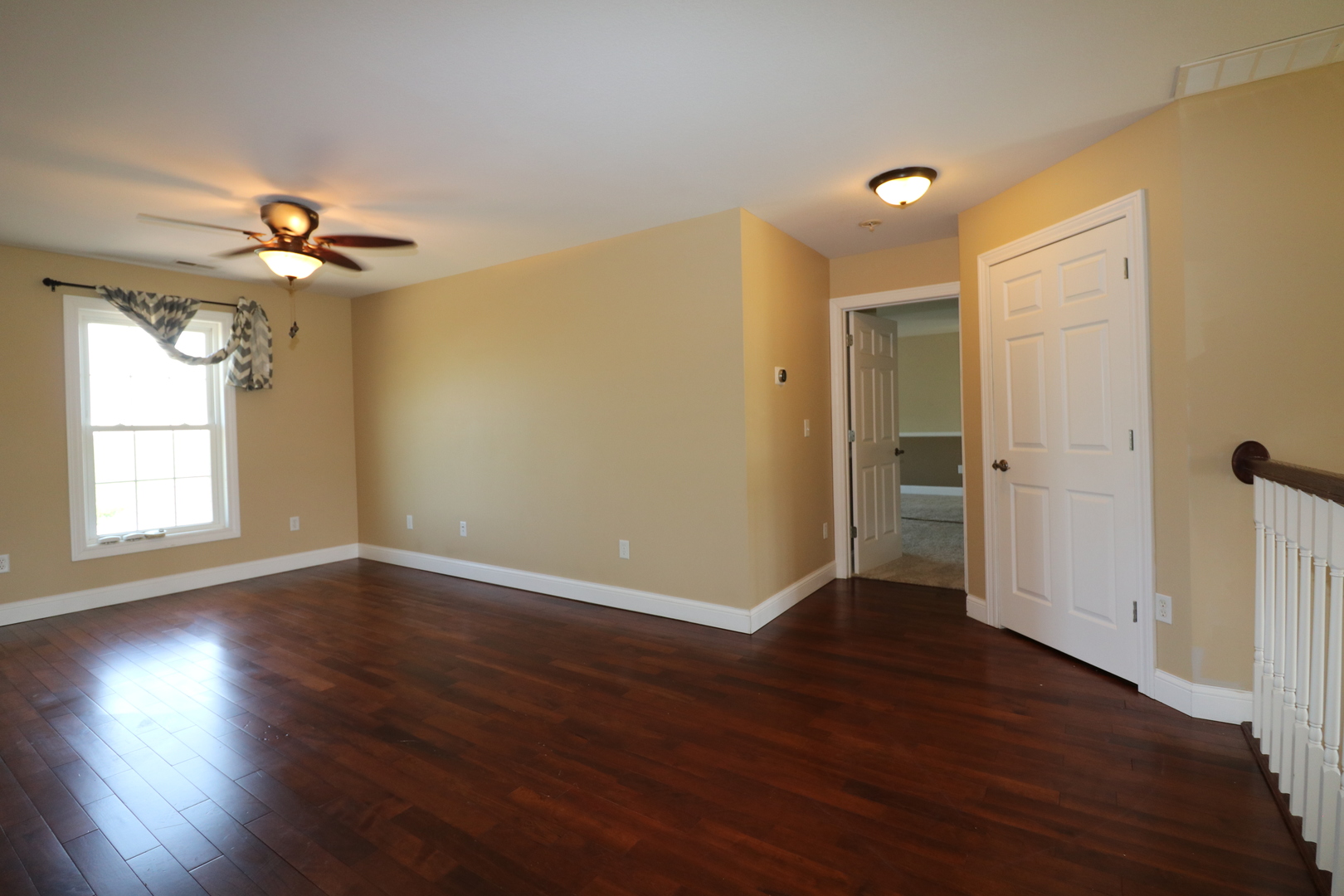 9358 Little Galilee Road Clinton, IL 61727 - Photo 23 of 40 an empty room with wooden floor chandelier fan and windows